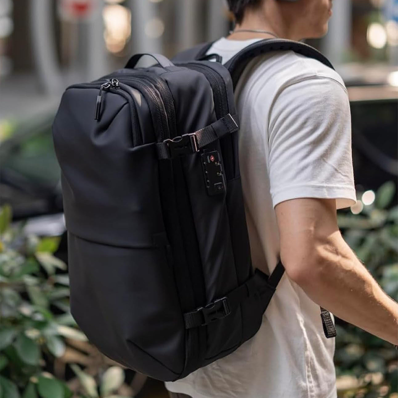 Person wearing a vacuum compression backpack and headphones, walking outdoors.